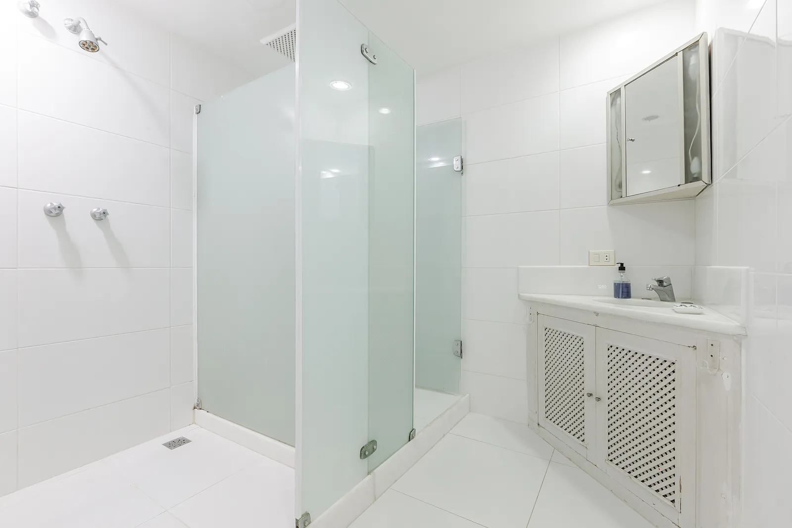 Une salle de bains avec douche en verre et un plan vasque