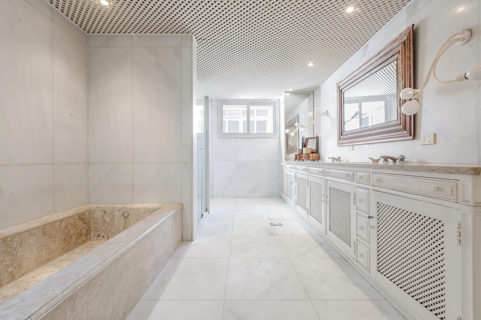 Une salle de bains en marbre avec baignoire et passage