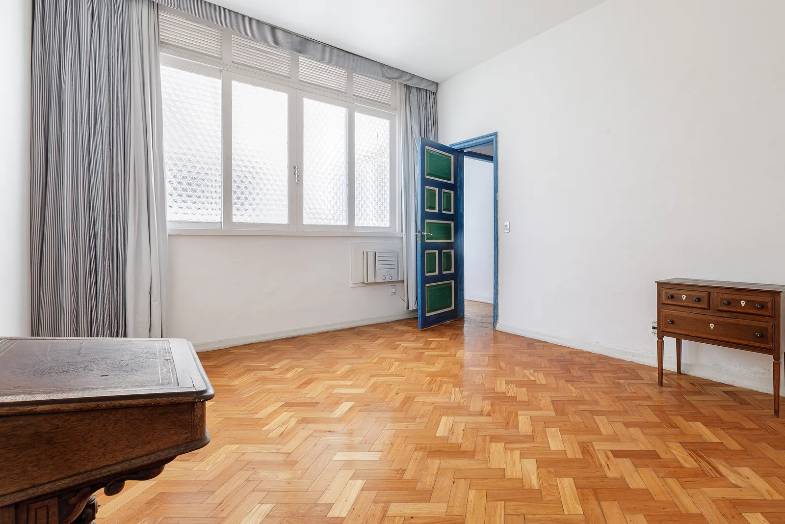 Une chambre avec un mur entier de fenêtres et un rideau à motifs