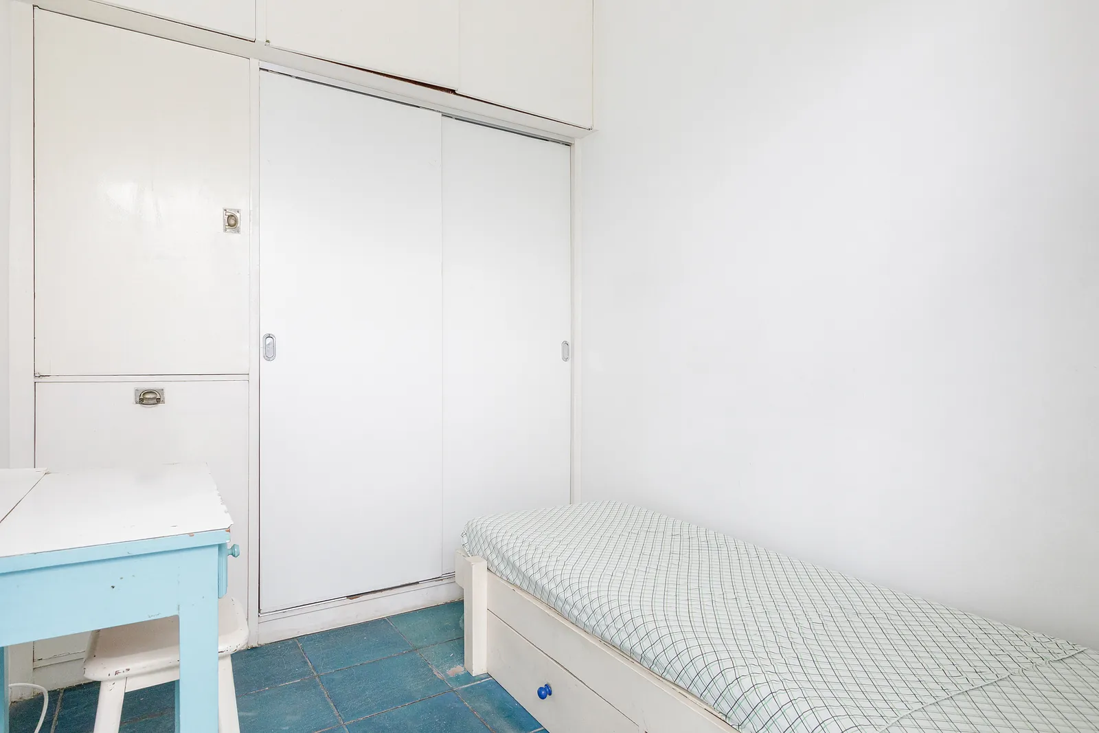 Une chambre simple avec un banc et un sol bleu