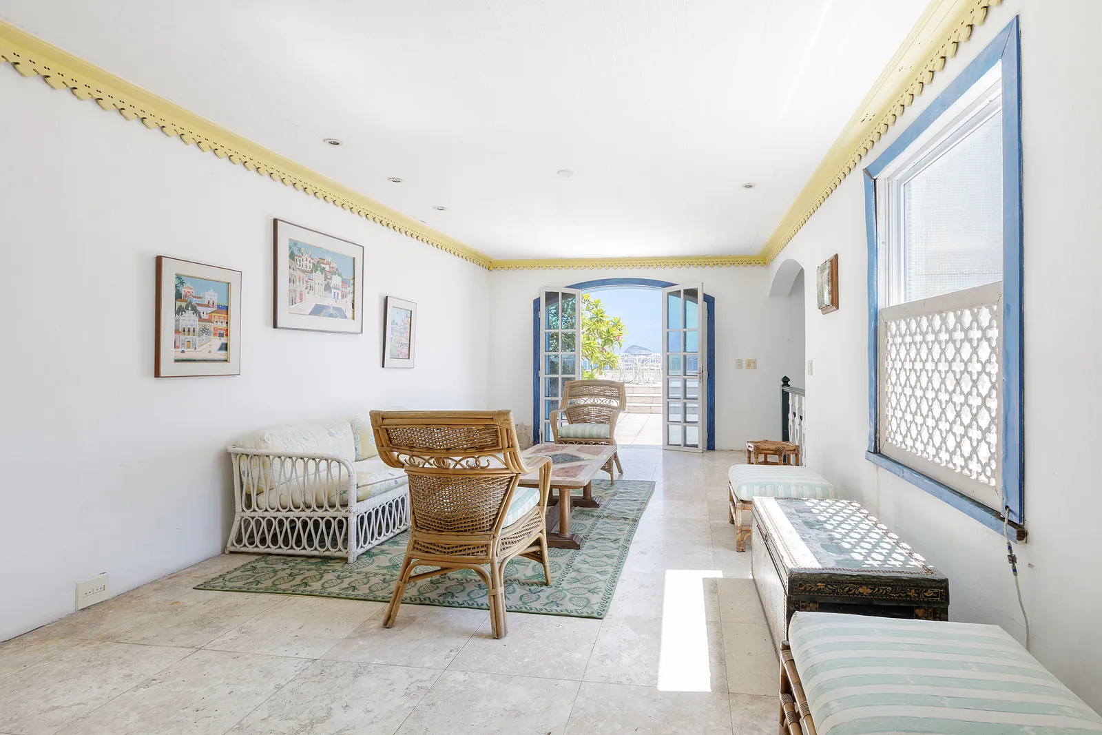 Un salon avec des œuvres et une fenêtre sur la terrasse