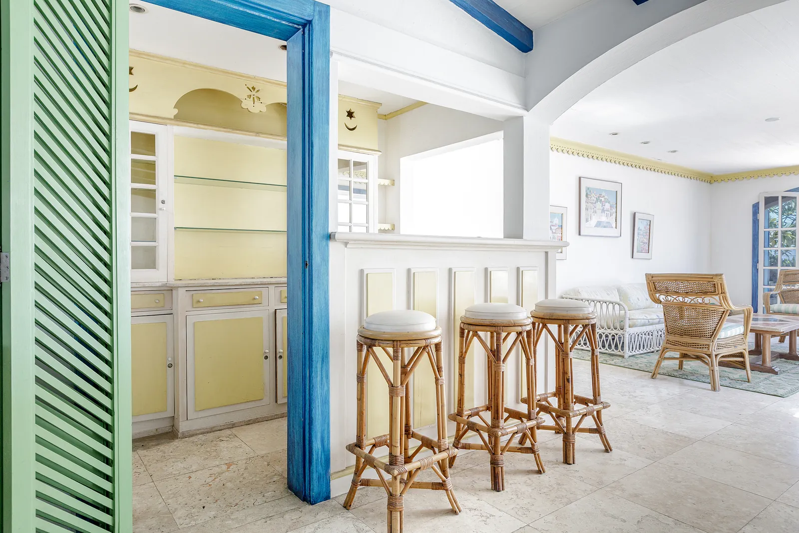 Un coin bar avec tabourets et portes à persiennes