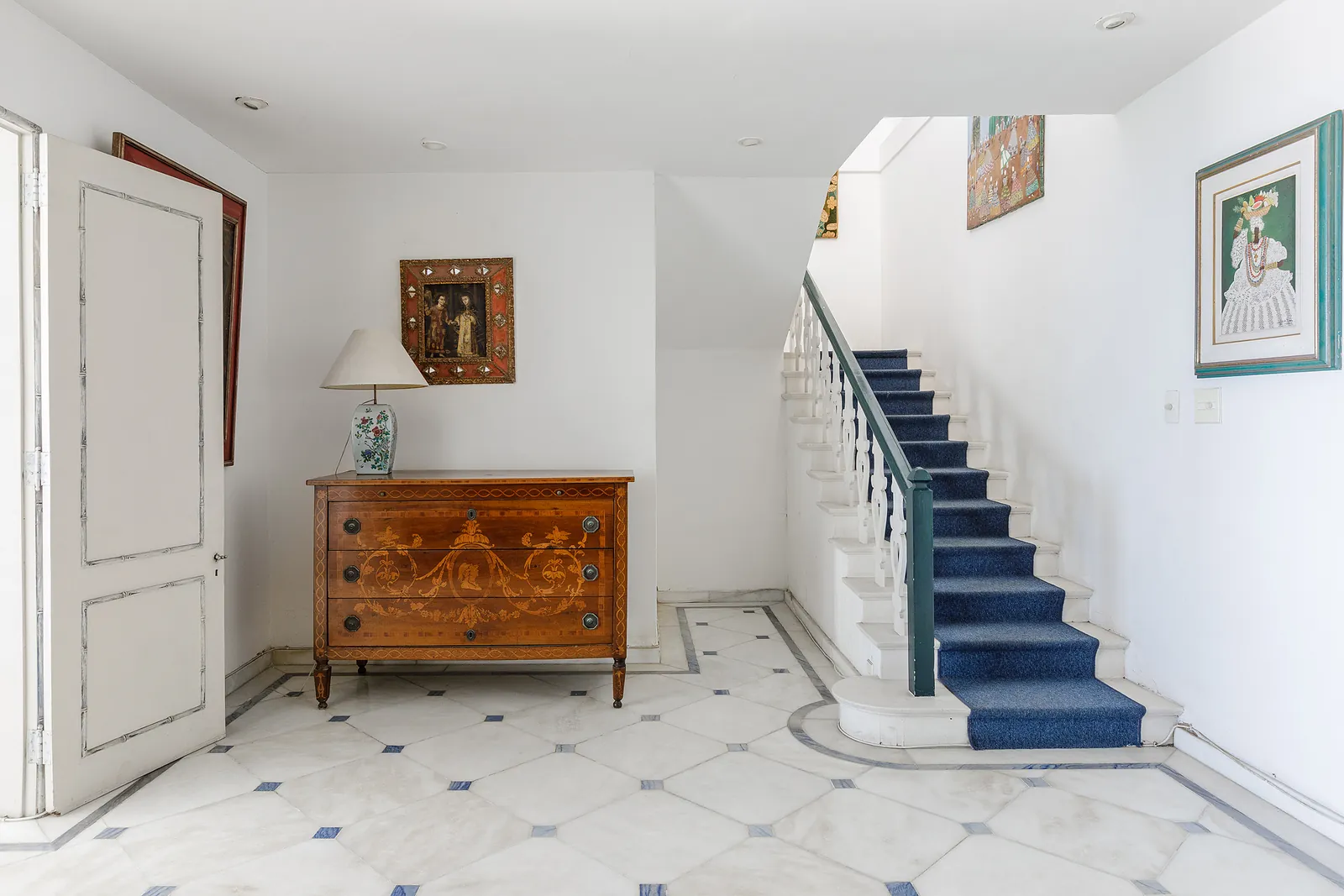 L'escalier intérieur, un tapis bleu et un coffre ancien