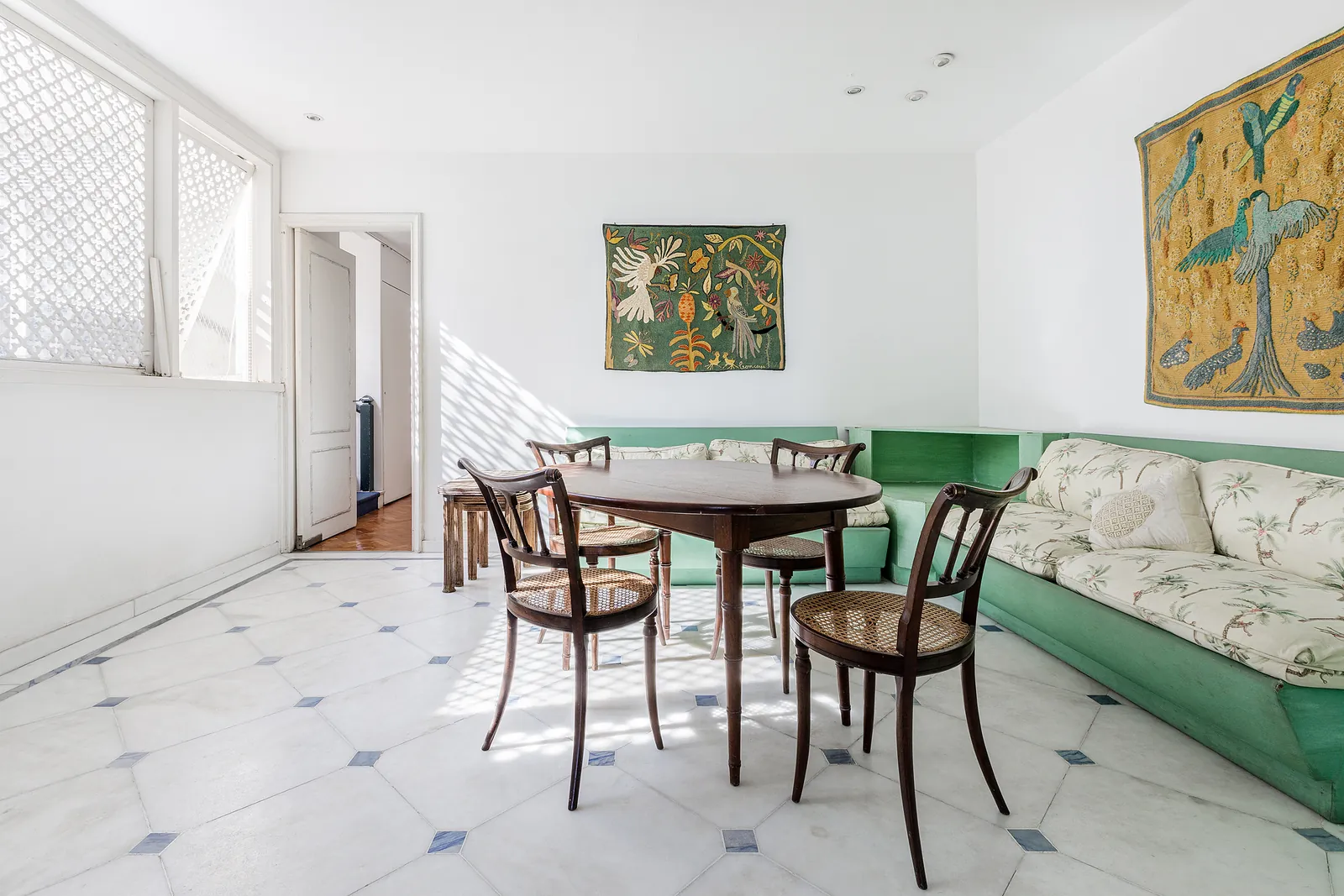Une salle à manger avec table ronde et un canapé vert