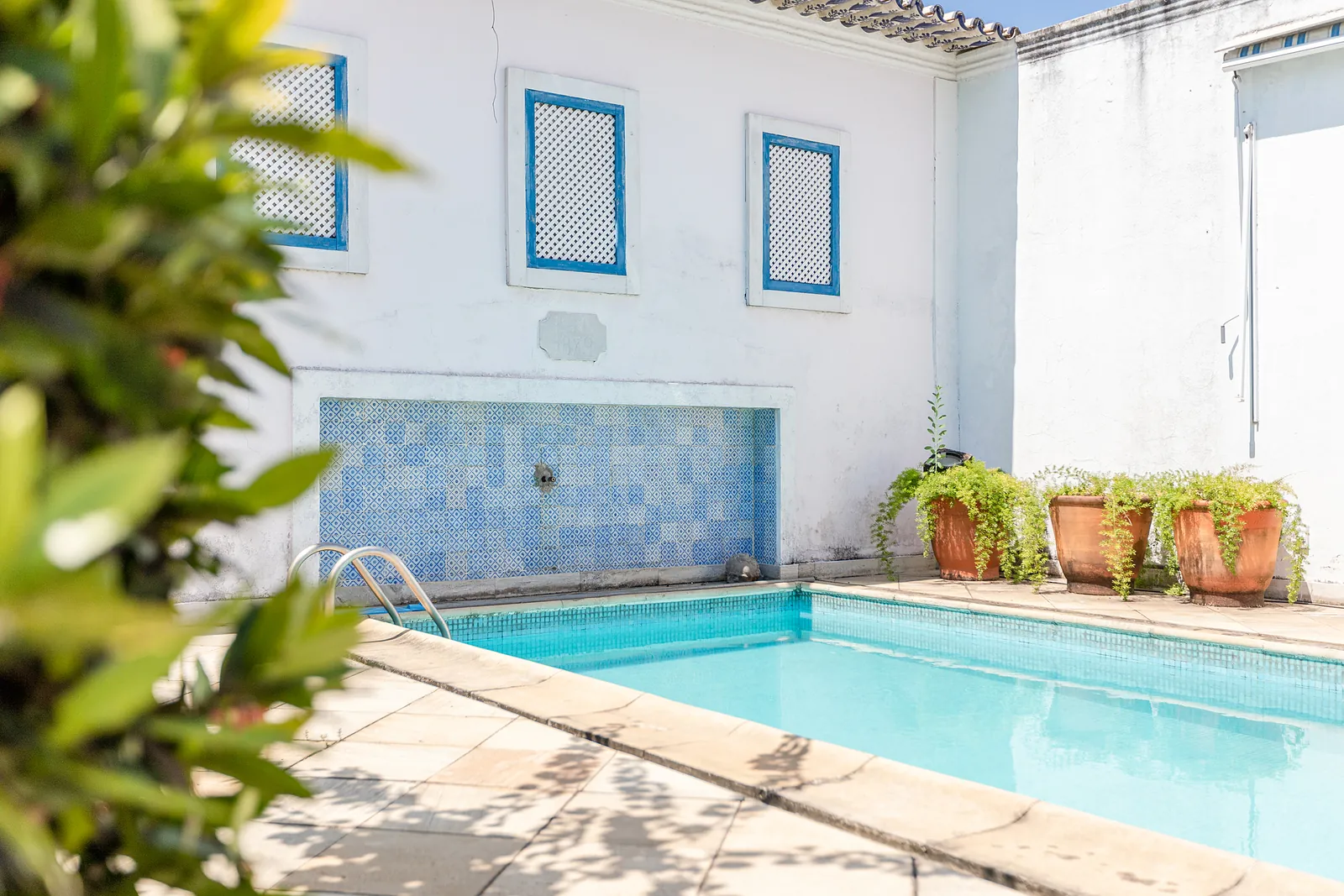 Un coin de la piscine près d'un mur-fontaine d'azulejos bleus