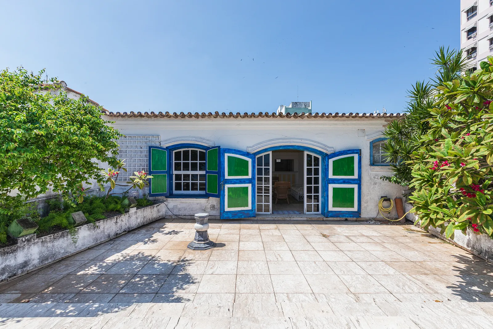 La maison sur le toit, ses portes à persiennes ouvrant sur la terrasse
